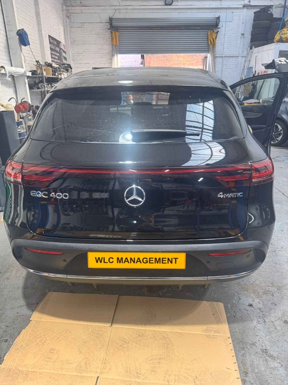 Black Mercedes-Benz EQC in the workshop, seen from the rear